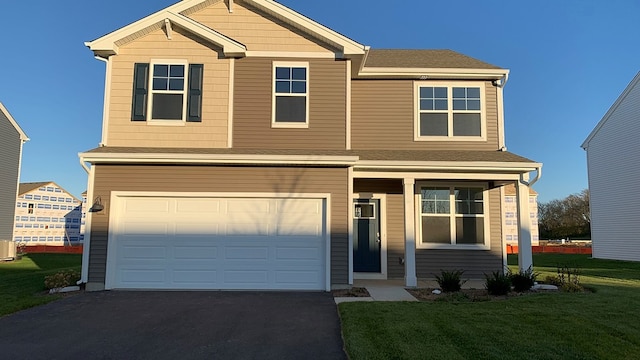 view of front of home with a garage and a front lawn