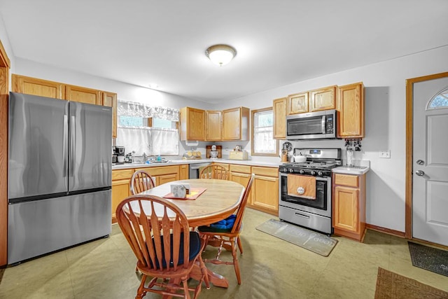 kitchen with appliances with stainless steel finishes, light brown cabinetry, and sink