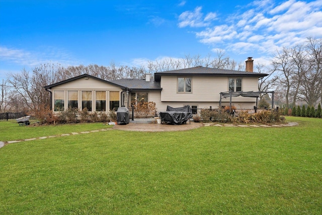 rear view of house featuring a sunroom and a lawn