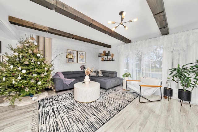 living room with beamed ceiling, a notable chandelier, and light hardwood / wood-style floors