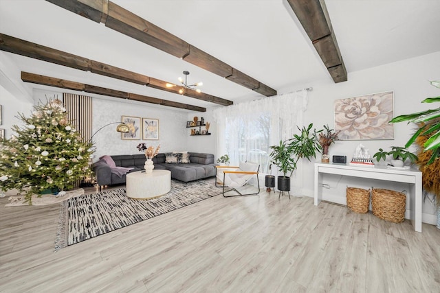 living room featuring beamed ceiling, light hardwood / wood-style floors, and a chandelier