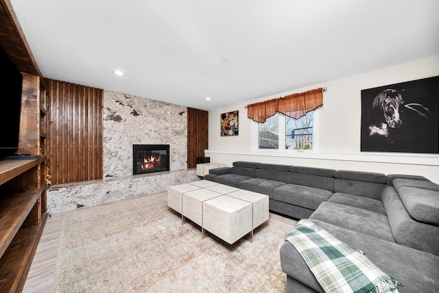 living room featuring a premium fireplace and wooden walls