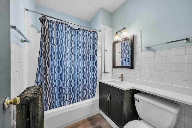 full bathroom featuring toilet, shower / bath combo with shower curtain, vanity, tile walls, and hardwood / wood-style flooring