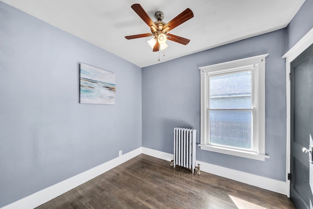 unfurnished room with dark hardwood / wood-style floors, radiator, and ceiling fan