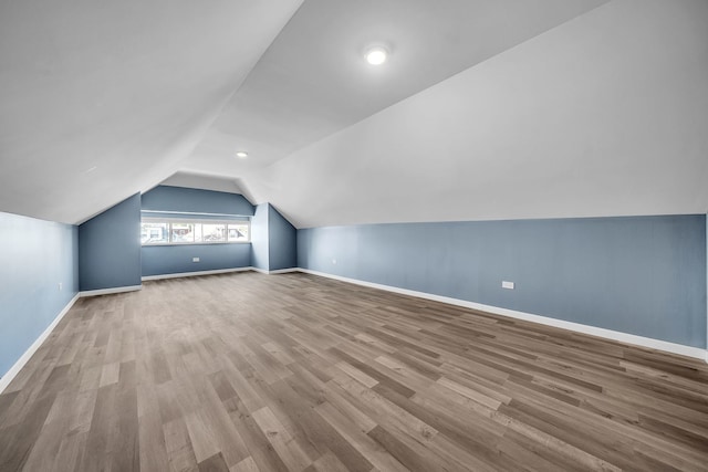 bonus room featuring vaulted ceiling and light hardwood / wood-style flooring