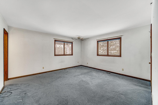 carpeted spare room featuring ceiling fan