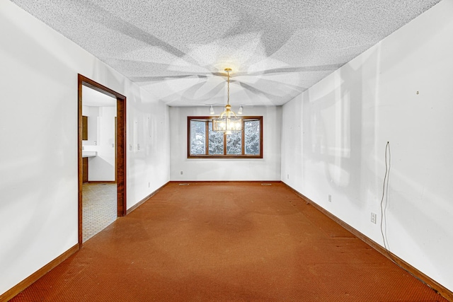 carpeted empty room with a textured ceiling and a chandelier