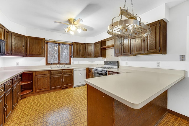 kitchen with sink, gas range oven, ceiling fan, kitchen peninsula, and white dishwasher