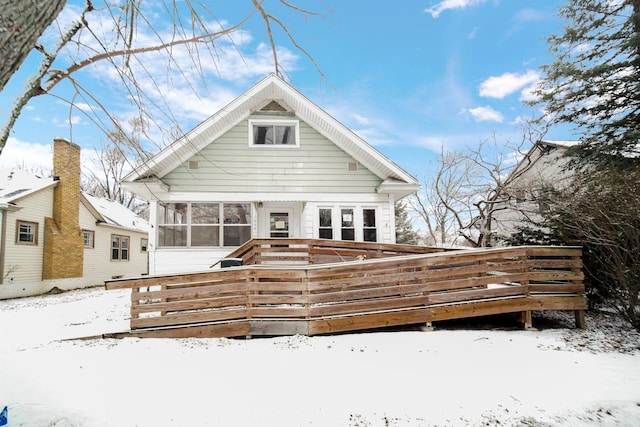 snow covered property featuring a deck and a sunroom