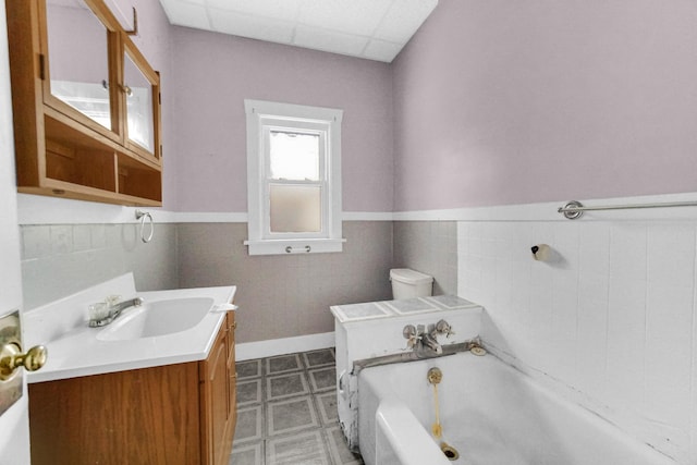 1009 Augusta Ave, Elgin, IL 60120 - bathroom featuring a tub, vanity, tile patterned floors, a wainscoted wall, and a paneled ceiling
