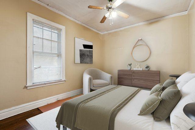 bedroom with dark hardwood / wood-style flooring, ceiling fan, and crown molding