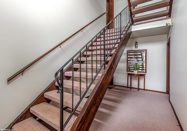 stairway featuring a high ceiling and carpet floors