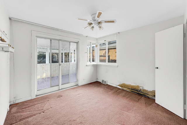 empty room featuring ceiling fan and dark carpet