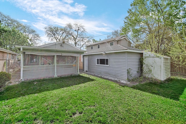 rear view of house with a sunroom and an outdoor structure