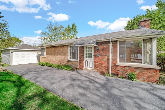 ranch-style home with an outbuilding, a chimney, brick siding, and a detached garage