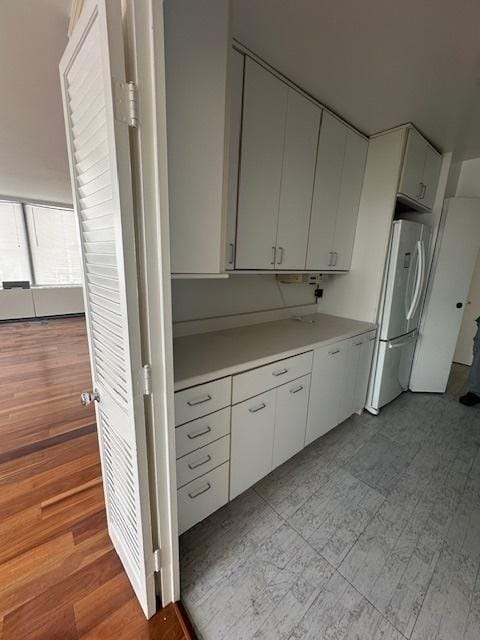 kitchen featuring white cabinets and white fridge