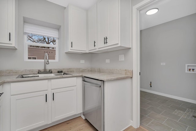 kitchen with tile patterned floors, white cabinetry, stainless steel dishwasher, and sink