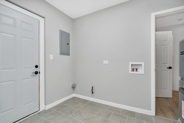 clothes washing area with electric panel, gas dryer hookup, light tile patterned floors, and washer hookup