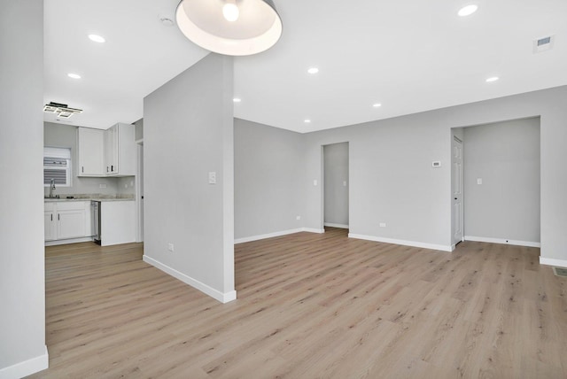 unfurnished living room with light hardwood / wood-style floors and sink