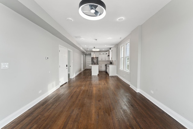 unfurnished living room with recessed lighting, baseboards, and dark wood-style floors