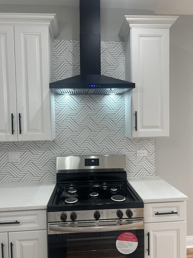 kitchen with decorative backsplash, white cabinetry, stainless steel electric range, and wall chimney range hood