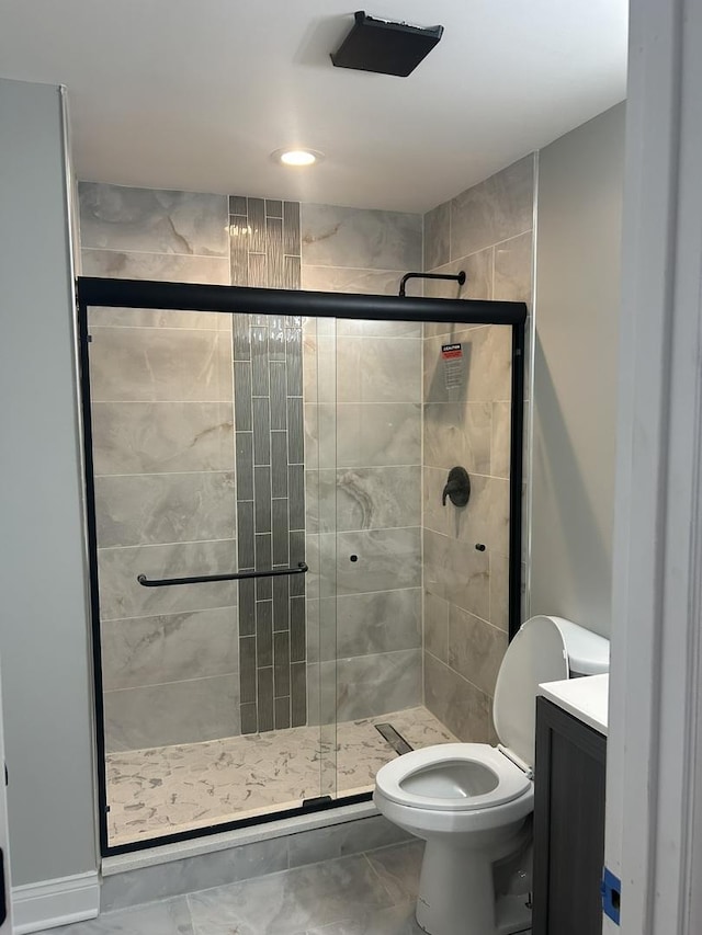 bathroom featuring toilet, a stall shower, and vanity