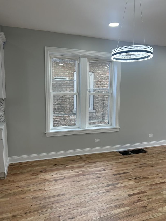 unfurnished dining area featuring recessed lighting, visible vents, baseboards, and wood finished floors