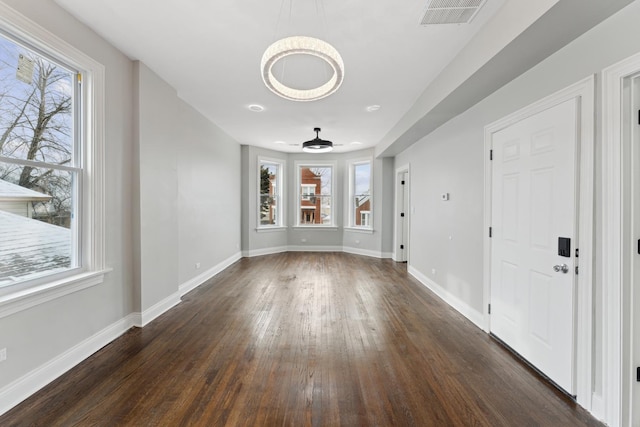 interior space with visible vents, baseboards, and dark wood finished floors