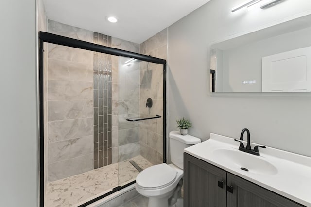 bathroom with a stall shower, toilet, and vanity