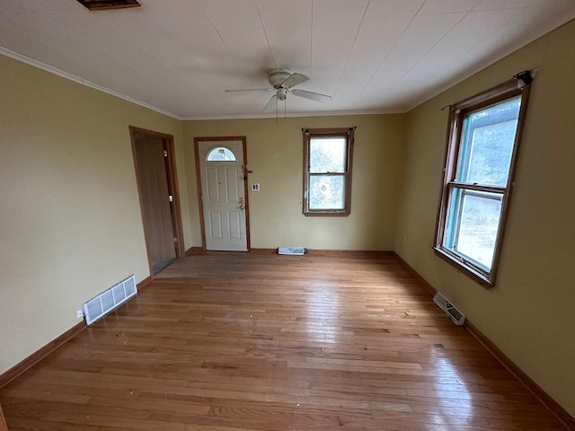 foyer entrance with light hardwood / wood-style flooring, ceiling fan, and crown molding