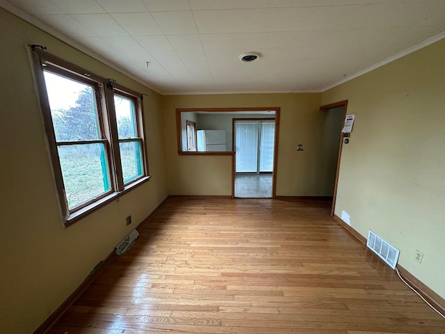 unfurnished room with light hardwood / wood-style flooring and crown molding