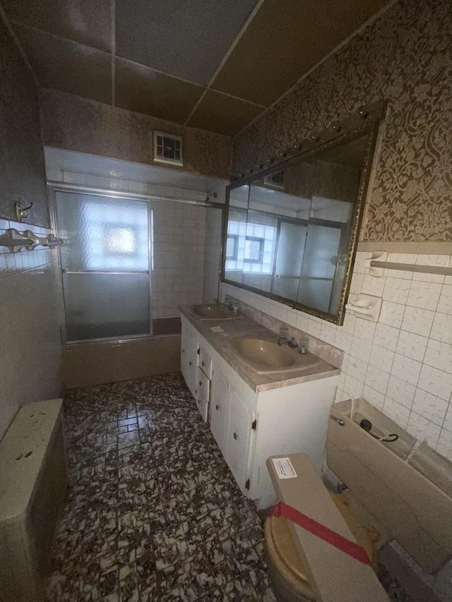 bathroom with vanity, toilet, and tile walls