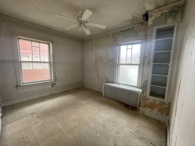 empty room with radiator, ornamental molding, and ceiling fan