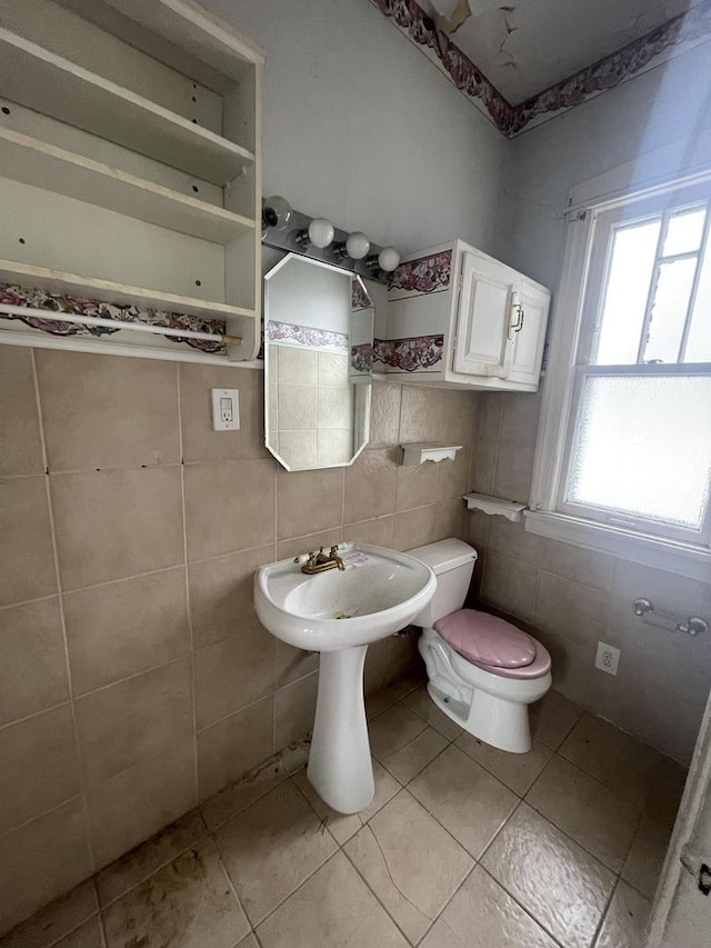 bathroom featuring tile patterned floors, tasteful backsplash, tile walls, and toilet