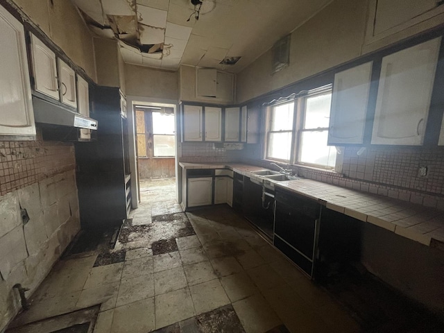 kitchen featuring backsplash, tile countertops, a healthy amount of sunlight, and sink