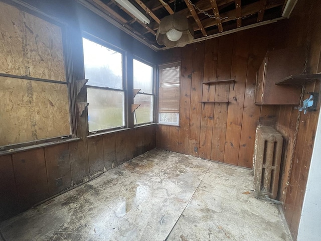 unfurnished room with radiator and wood walls