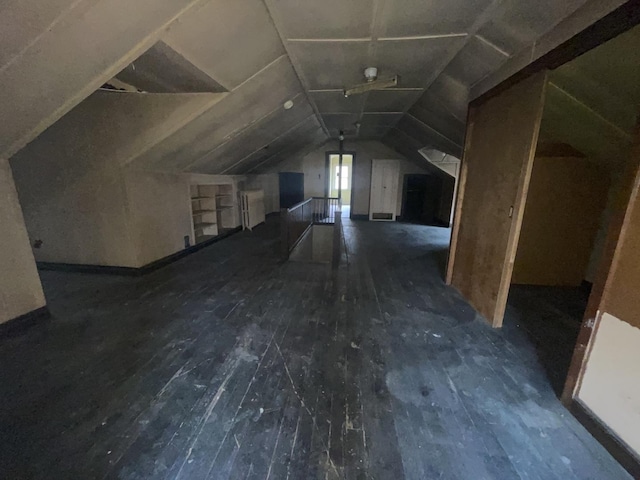 bonus room with built in shelves, dark hardwood / wood-style flooring, and lofted ceiling