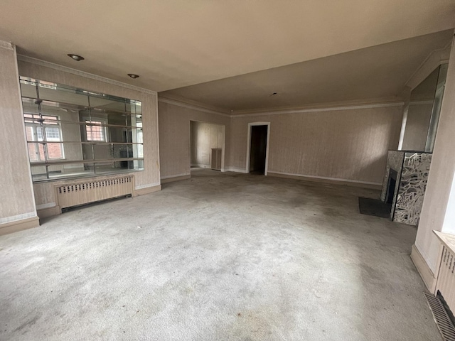 unfurnished living room with light colored carpet and radiator