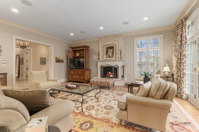 living room with a chandelier, a large fireplace, light wood-type flooring, and crown molding