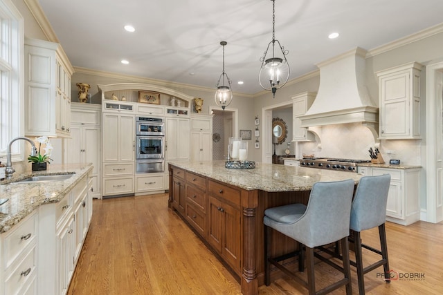 kitchen with a center island, premium range hood, pendant lighting, decorative backsplash, and sink