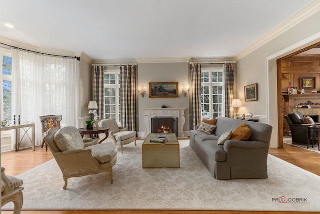 living room featuring a wealth of natural light, light wood-type flooring, and crown molding