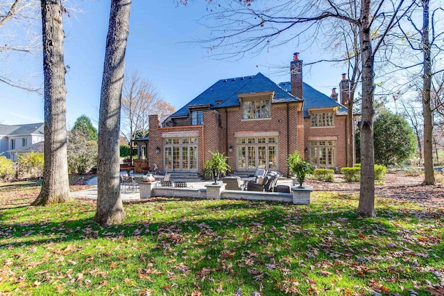 back of property featuring a lawn, french doors, and a patio area