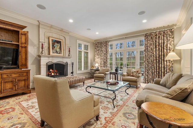 living room with a large fireplace, light wood-type flooring, and crown molding