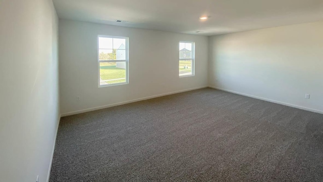 unfurnished room featuring dark colored carpet