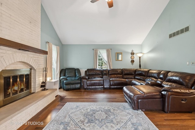 living room with dark hardwood / wood-style floors, a brick fireplace, ceiling fan, and lofted ceiling