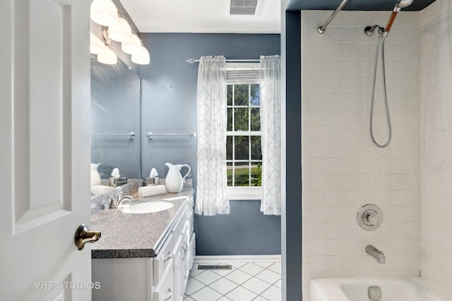 bathroom with tile patterned flooring, vanity, tiled shower / bath combo, and plenty of natural light