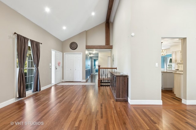 foyer entrance with beamed ceiling, high vaulted ceiling, and hardwood / wood-style flooring