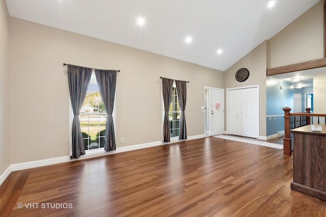 living room with high vaulted ceiling and hardwood / wood-style flooring