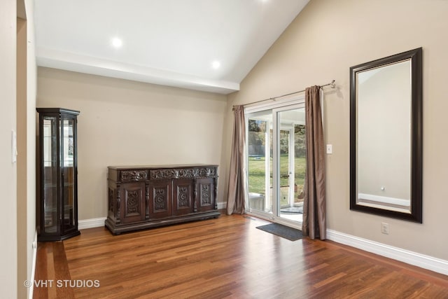 spare room featuring hardwood / wood-style floors and high vaulted ceiling