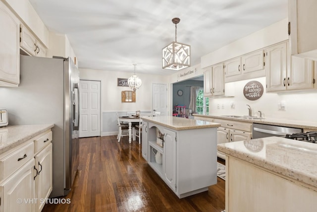 kitchen featuring pendant lighting, a kitchen island, dark wood-type flooring, and light stone counters